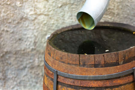 Drain pipe in a barrel. Drainage of rainwater not into the sewer, but into a wooden barrel. When there is no storm sewer.の写真素材