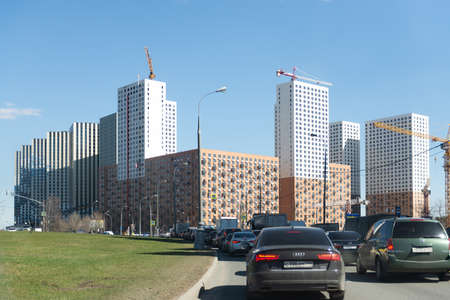 Moscow. Russia. Spring 2019. Construction of new huge residential buildings in the south of Moscow. Huge multi-storey buildings loom over the roadのeditorial素材