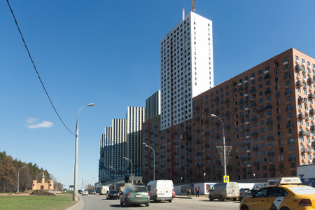 Moscow. Russia. Spring 2019. Construction of new huge residential buildings in the south of Moscow. Huge multi-storey buildings loom over the roadのeditorial素材