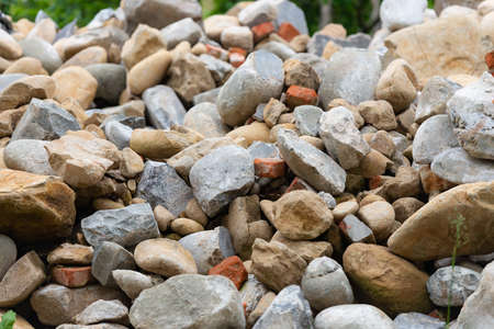 A pile of stones and after dismantling a stone house. Stones used in the cladding of an old house.の写真素材