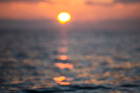 Unfocused sunset on the sea. Orange colors of the low sun in the Mediterranean Sea.の写真素材