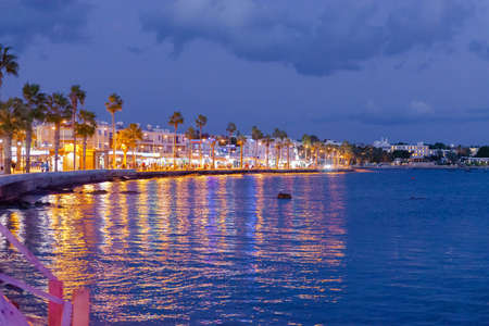 Pathos. Cyprus. November 2019. Evening promenade in the city of Paphos. The shore of the resort town under the light of lanterns. People walk along the embankment and shopping malls.のeditorial素材