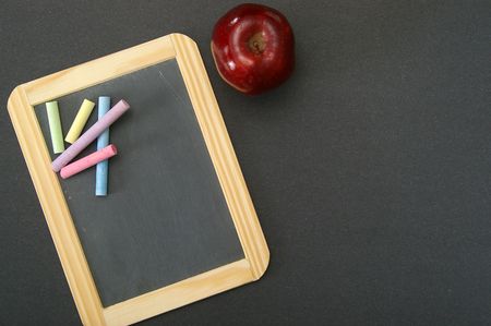 Overhead view of a teacher's desk, with chalkboard and apple. Plenty of area for your own text.の写真素材