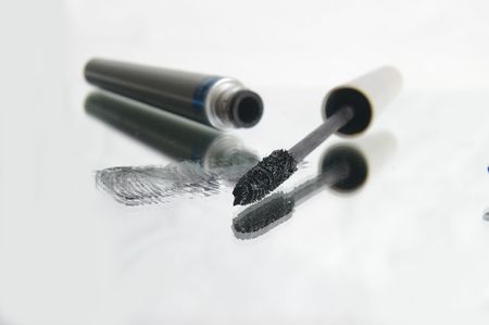 Black mascara smudged on a mirror. Focus is on applicator area of wand.の写真素材