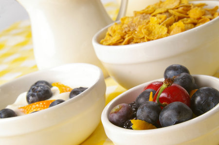 Bowl of berries, served along with cereal, yogurt and a pitcher of fresh milk. Shallow focus on...