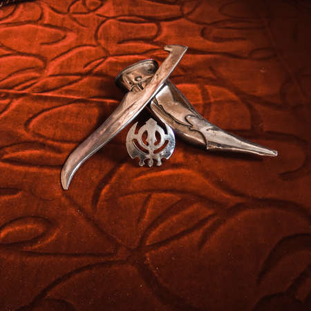 Knife with scabbard and khalsa monogram. The khalsa monogram is a prestigious symbol in Sikh religion. The style of knife featured is also known as 'kirpan'.の写真素材