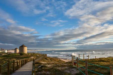 Beautiful landscape of old traditional windmills on the coastal path of Apulia beach in Portugalの写真素材