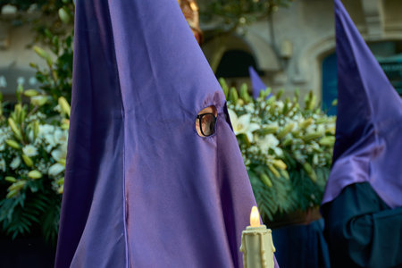 Vigo, Pontevedra, Spain; April, 06,2023; Nazarene marching in the Holy Week procession with a candle