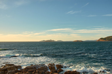Panoramic view from Montereal in Bayona, Pontevedra, Spain, showing the majestic CÃ­es Islands, Estelas Islands, and Monteferro. The image highlights the unique coastal beauty of Galicia, with the islands emerging from the Atlantic Ocean and Monteferro standing tall in the background.の写真素材