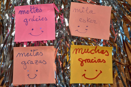 This image showcases four colorful notes expressing gratitude in Spain's four official languages: Castilian, Galician, Catalan, and Basque. Each note reflects the rich linguistic diversity of Spain, symbolizing unity in diversity. The bright colors of the notes against a simple background highlight the messages, making it a perfect visual for Thank You Day.の写真素材