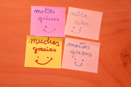 This image showcases four colorful notes expressing gratitude in Spain's four official languages: Castilian, Galician, Catalan, and Basque. Each note reflects the rich linguistic diversity of Spain, symbolizing unity in diversity. The bright colors of the notes against a simple background highlight the messages, making it a perfect visual for Thank You Day.の写真素材