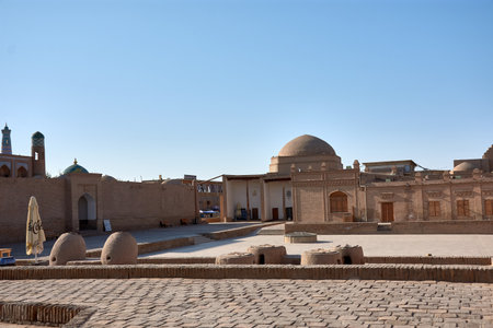 The ancient streets and monuments within the walls of Itchan Kala, the historic fortress in Khiva, Uzbekistan. As a UNESCO World Heritage Site, Itchan Kala is filled with stunning examples of Islamic architecture, including mosques, madrasahs, and minarets. The narrow streets are lined with centuries-old buildings, offering visitors a glimpse into Khiva's rich past along the Silk Road.の写真素材