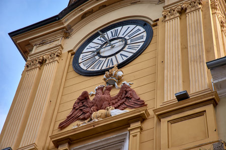 Clock Tower, a prominent monument located on Korzo Street in the center of Rijeka, Croatia. The Clock Tower, with its striking yellow facade and arched structure, is one of Rijeka's most recognizable landmarks. Dating back to the 18th century, it serves as a gateway to the old town and is adorned with a clock and the city's coat of arms. The tower stands tall in Korzo, a bustling pedestrian street filled with shops, cafes, and historical buildings.の写真素材