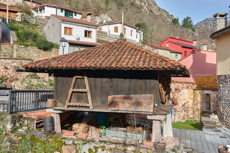 Capture the essence of rural Asturias with this image of a beautifully restored hÃ³rreo in Pola de Somiedo. These traditional structures, unique to the region, were used for storing grain and other agricultural products. The image showcases the hÃ³rreo's rustic charm, with its weathered wooden construction, stone supports, and tiled roof.の写真素材