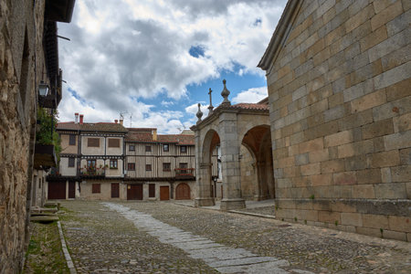 Cobbled alley in La Alberca flanked by traditional stone and half-timbered houses, with balconies...