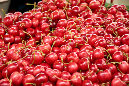 Close-up of a large quantity of bright red cherries stacked on a market stall in Aix-en-Provence,...
