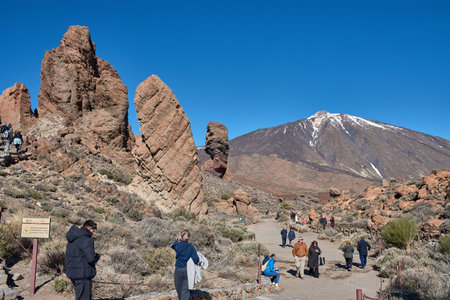 Teide, Tenerife, January 13, 2026, A group of visitors walks along the trails of ocher sand and basalt rocks that extend at the foot of the imposing Mount Teide. The composition uses the contrast between the earthy tones of the volcanic desert and the vibのeditorial素材