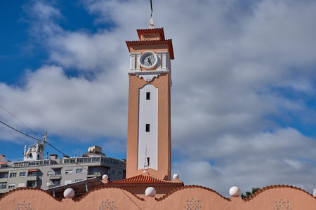 This neo-colonial style clock tower stands out with its vibrant salmon color and white details...