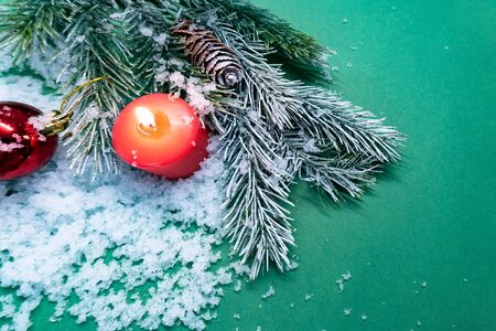 New year and christmas concept. There are candle, pine branches and snow on green background. View from the top.の写真素材