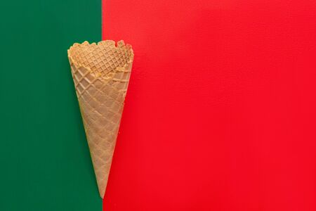 Top view at the empty waffle cone on red and green background, special concept, enough place for text, diagonal positionの写真素材