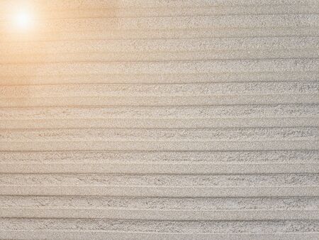 Beautiful artificial pattern on sand arter going a track or any other transport. There is sun lights from the left. Good for background, enough place for textの写真素材