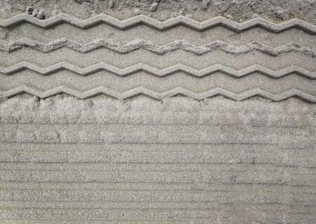 Beautiful artificial pattern on sand arter going a track or any other transport. Good for background, enough place for textの写真素材