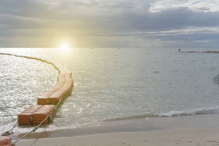 Sunset or sunrise with the view of calm and no waves sea with modular floating pontons and sand at asian resort at summer. Good backgroundの写真素材