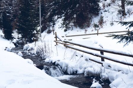 View at the river in winter, snow all around, winter forest, fence. Good for background.の写真素材