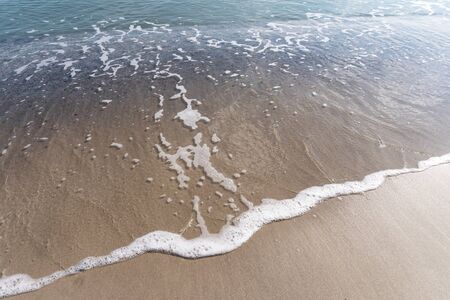Water from the sea oÐº ocean on the sand at the beach, view from the top.の写真素材