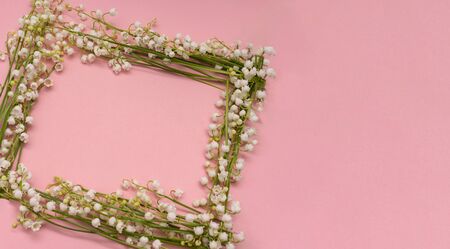 Frame from lily of the valley flowers on pink background, copy space, wedding concept.の写真素材
