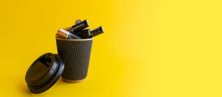 Kiev, Urkaine, 16 June 2020, Duracell AA alkaline batteries are in coffee takeaway cup as association of energy, yellow background, creative idea of using batteries. Enough space for text.のeditorial素材