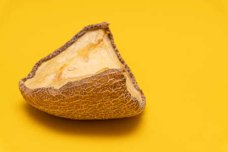 View at moldy dried melon at yellow background, copy space, spoiled product, closeup, not edibleの写真素材