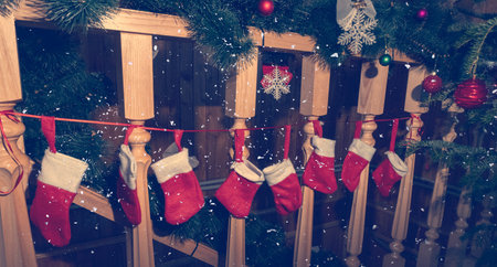 Christmas socks hanging on wooden stairs near fur tree with christmas toys, snowing, christmas and...