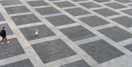Man and little caucasian child walking at the street as pedestrian, at pavement from grey bricks, view from the top, urban life, outdoor, copy space.の写真素材
