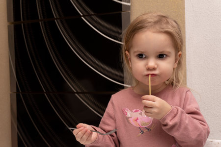 Cute little caucasian child eating italian pasta and thinking, tasty delicious spaghetti dish, copy space, lunch time.の写真素材