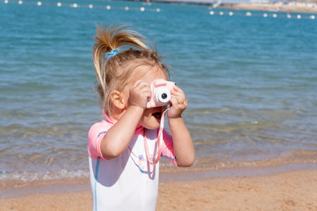 Cute little caucasian baby girl is making photos for family memory at summer vacation, young...