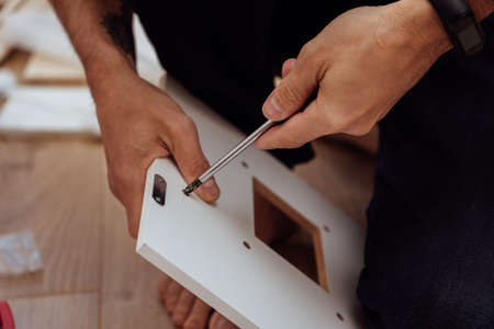 Man fixing home furniture with screwdriver, closeup.の写真素材