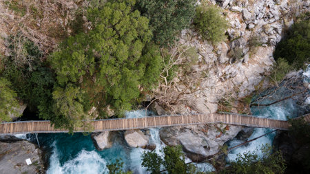 Aerial view strong fast river and wooden path near high rocks. Turkey, canyon. Drone shot, summer time, outdoor travel activity.の写真素材