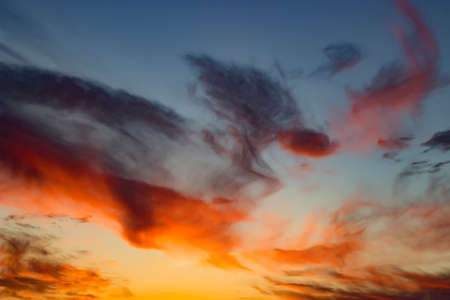 Incredible lines of translucent red yellow clouds in the evening sky. beautiful spring sunset.の写真素材