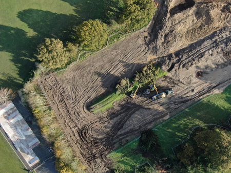 An aerial view of machinery ripping out trees and bushes