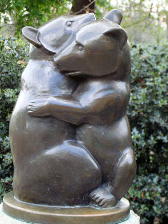 small bronze statue of two small bears hugging or playingの写真素材