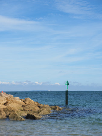 Portrait format picture of shoreline near sandbanks in Poole with the Isle of Wight in the distant backgroundの写真素材