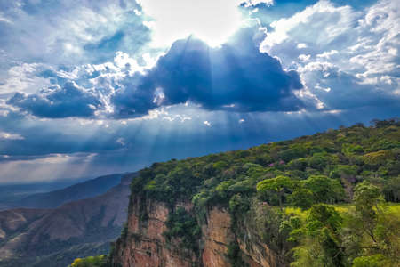 Dramatic view of cliffs with rainforest, sunrays falling through storm clouds, Chapada dos Guimaraesの写真素材