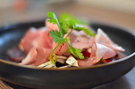 local homemade sausages, ham, olives on a wooden board salad black Plate, backgroundの写真素材