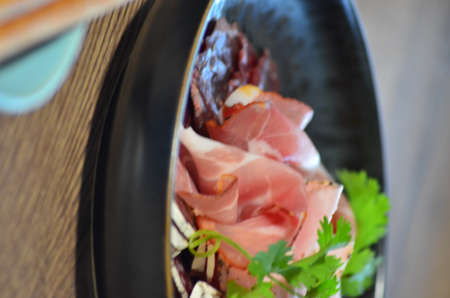 local homemade sausages, ham, olives on a wooden board salad black Plate, backgroundの写真素材