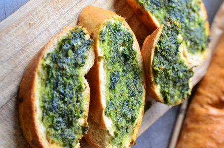 Toasted baguette with pesto on cutting board, closeupの写真素材