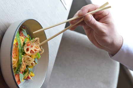 Man eating asian noodle with chopsticks in restaurant, closeupの写真素材