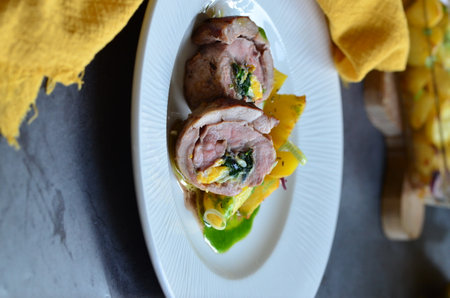 Pork tenderloin stuffed with spinach and cheese on a plateの写真素材