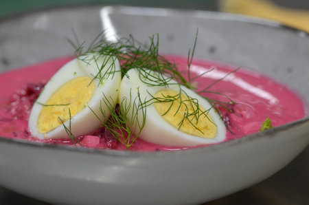 Cold beetroot soup with egg and dill in a white bowlの写真素材