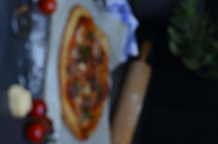 Blurred image of pizza on a wooden table. Blurred background.の写真素材